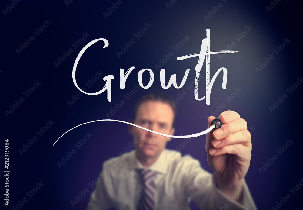 A businessman writing a growth concept with a white pen on a clear screen. A businessman writing a growth concept with a white pen on a clear screen.
