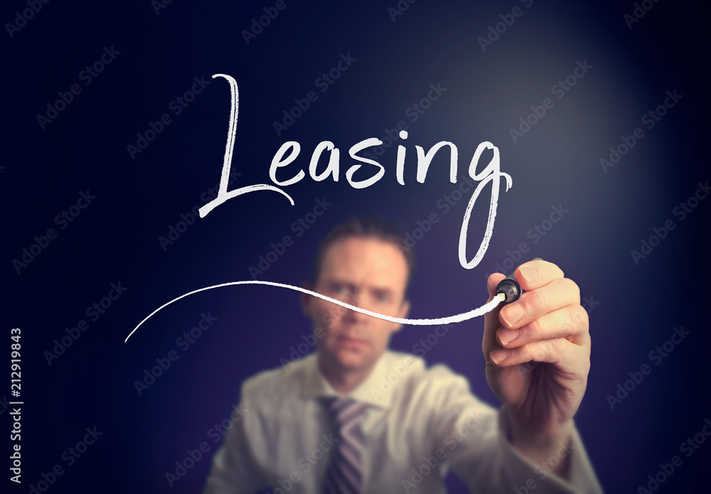 A businessman writing a leasing concept with a white pen on a clear screen. A businessman writing a leasing concept with a white pen on a clear screen.