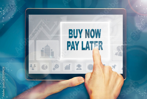 A hand holiding a computer tablet and pressing a buy now pay later business concept. photo