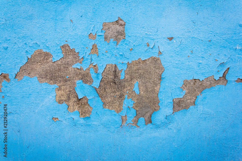 Concrete wall with old cracked blue paint. Texture and background