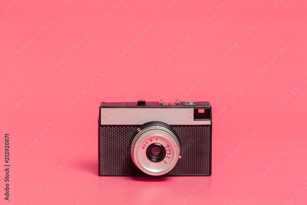 Vintage camera on pink background front view