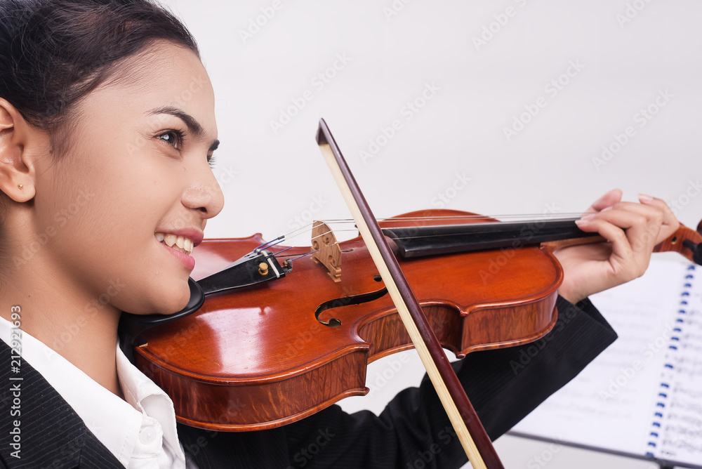 The student is playing violin,in classroom,practice time,with smile and happy face,blurry light around The student is playing violin,in classroom,practice time,with smile and happy face,blurry light around