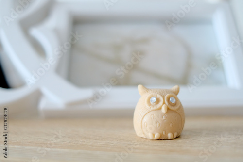 Small brown owl accessory with rocks in eyes on a wooden shelf