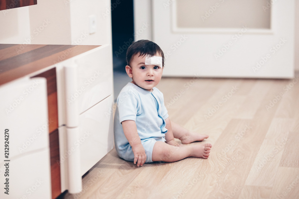 baby boy with bandage on his forehead
