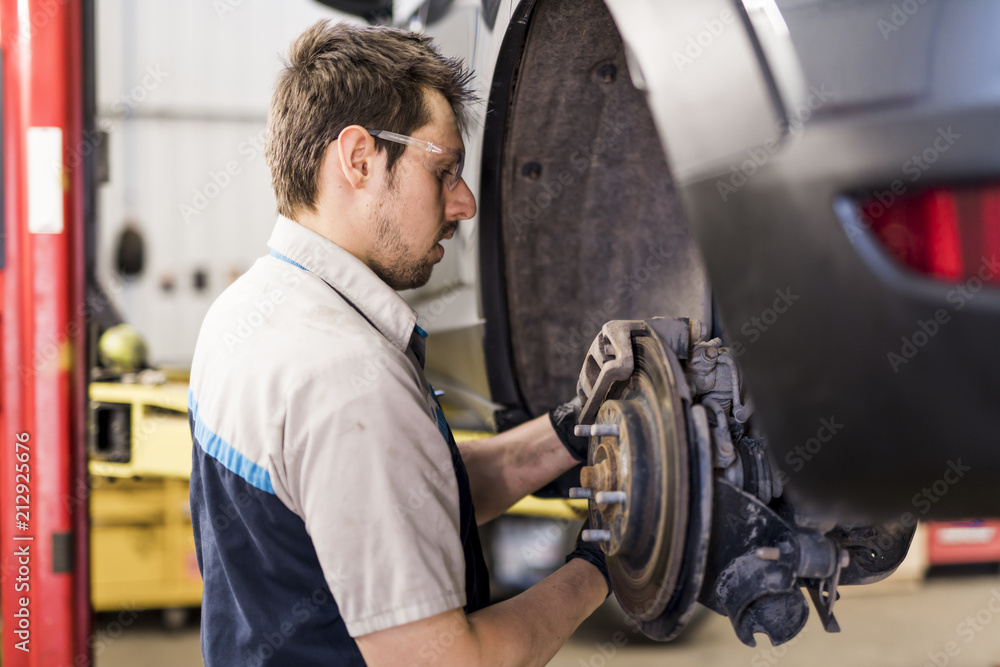 Handsome mechanic job in uniform working on car