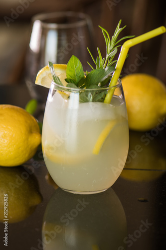 Glass of lemonade with straw and slice of lemon