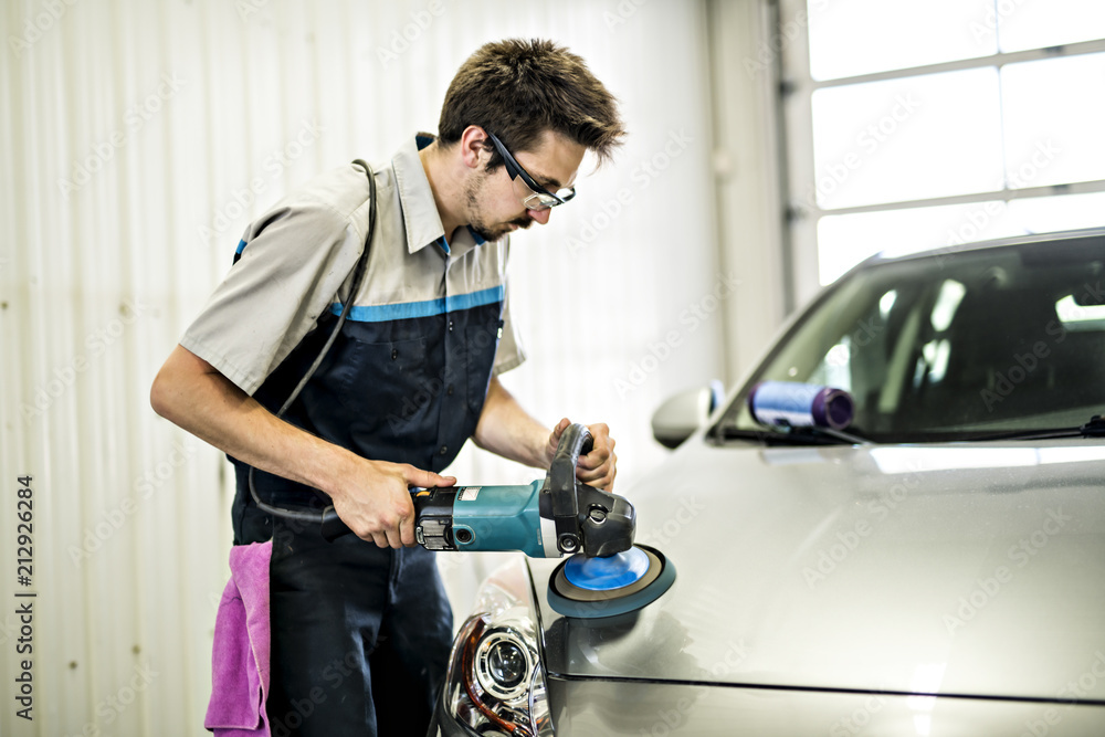 Man at work cleaning automobile at car wash waxy Man at work cleaning automobile at car wash waxy