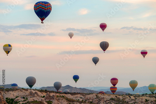 Hot air balloons at sunrise flying over Cappadocia, Goreme, Turkey.