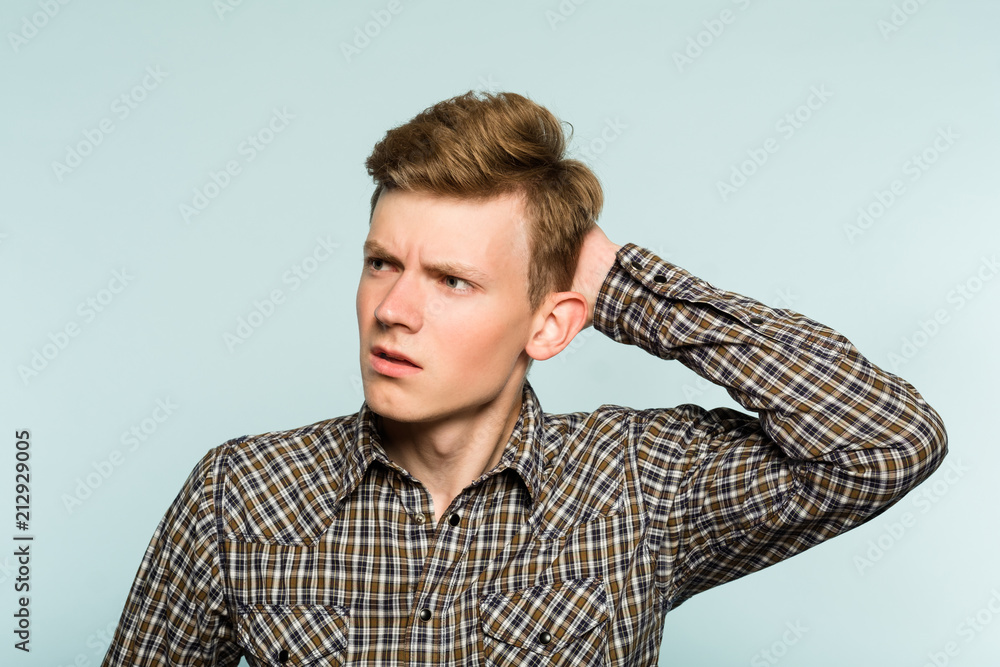 Stockfoto perplexed baffled confused man scratching head and looking
