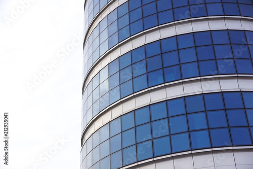 Reflexion of blue sky with clouds in building windows.