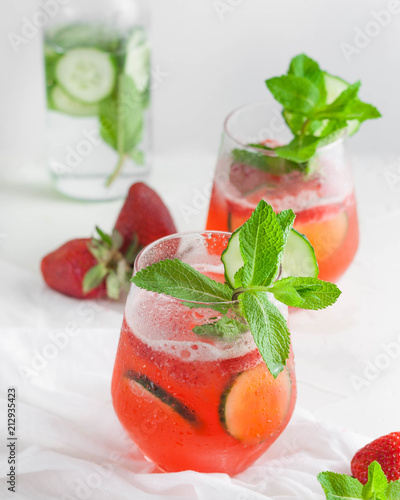 Iced coctail with strawberries, cucamber and mint. On a white background. photo