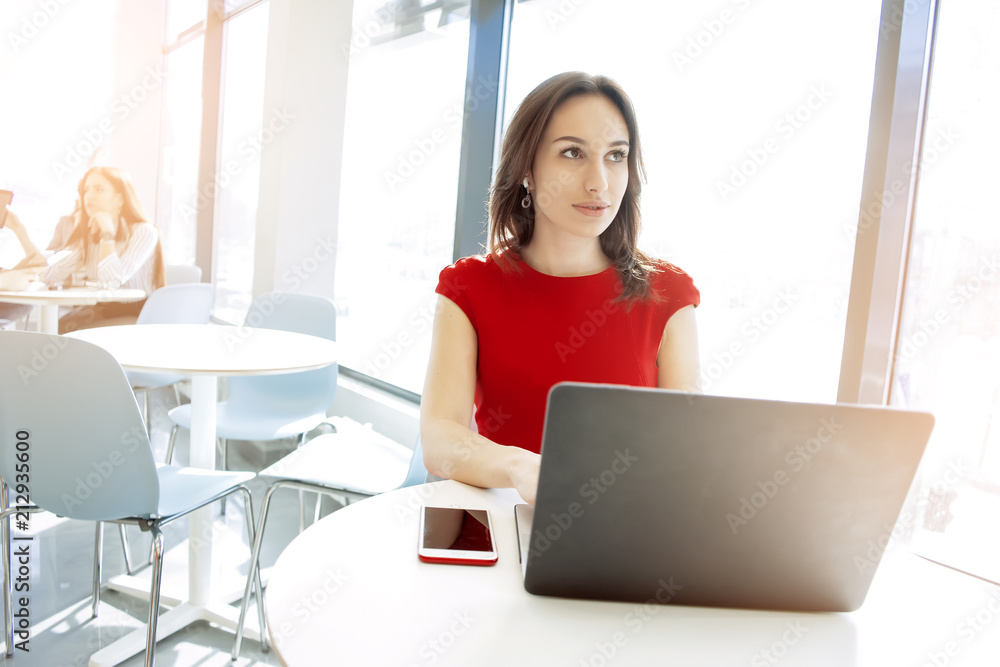 Shot of an executive businesswoman working on her laptop in office while business people consulting in the background. Shot of an executive businesswoman working on her laptop in office while business people consulting in the background.