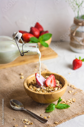 Homemade granola with fresh milk and strawberries for healthy breakfast