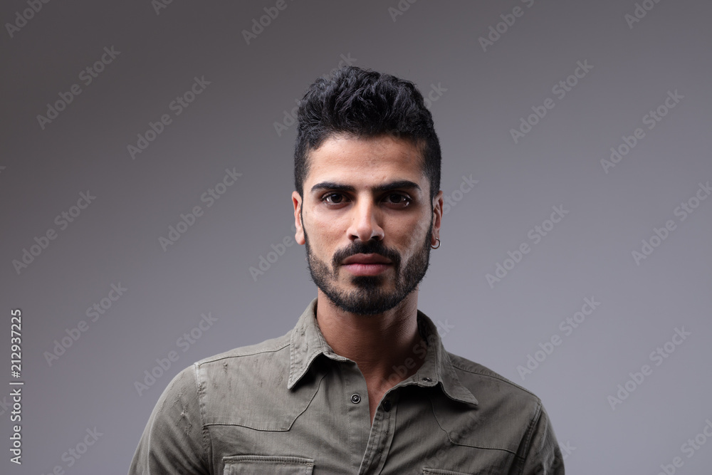 Young man with beard wearing grey button shirt