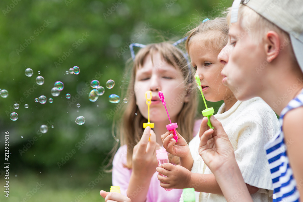 Fototapeta premium children blowing soap bubbles