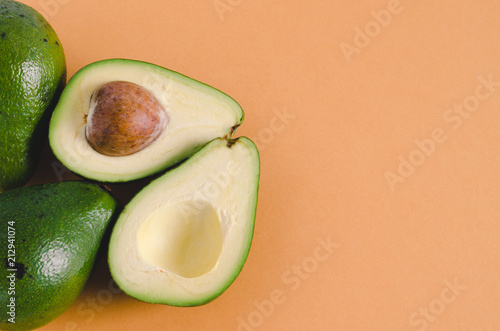 Avocados cut on color background. Flat lay.