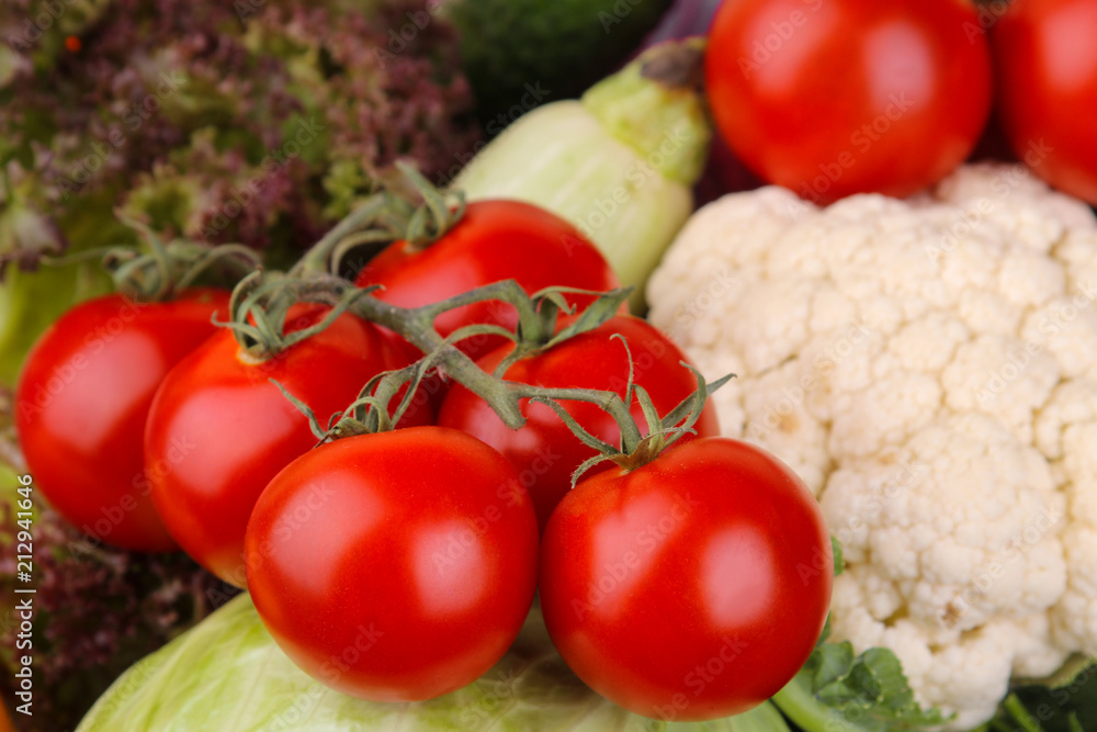 Different vegetables including tomatoes, zucchini, cauliflower and lettuce close-up. Background Different vegetables including tomatoes, zucchini, cauliflower and lettuce close-up. Background