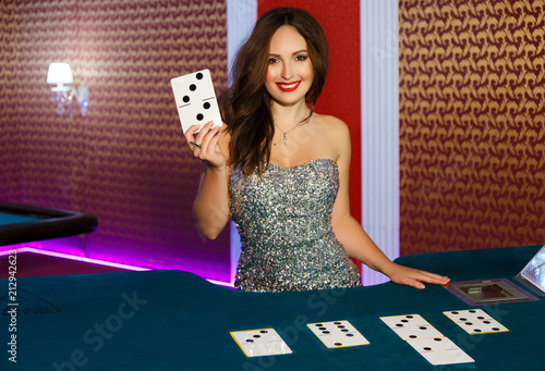 Dealer in the casino at the poker table. The dealer gives out cards.The dealer's hands are prevented by poker cards