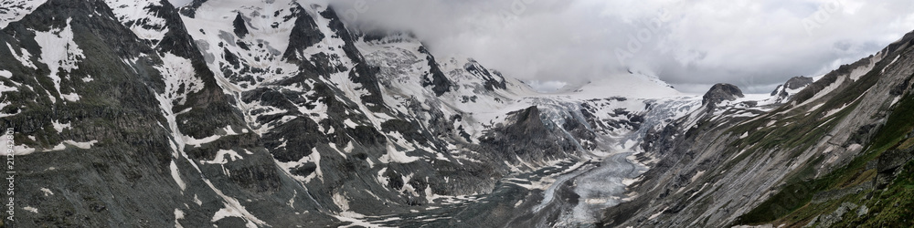 Weites Panorama: links Felswand mit Schnee, rechts Johannisberg schneebedeckt und Gletscher Pasterze in den Alpen von Österreich