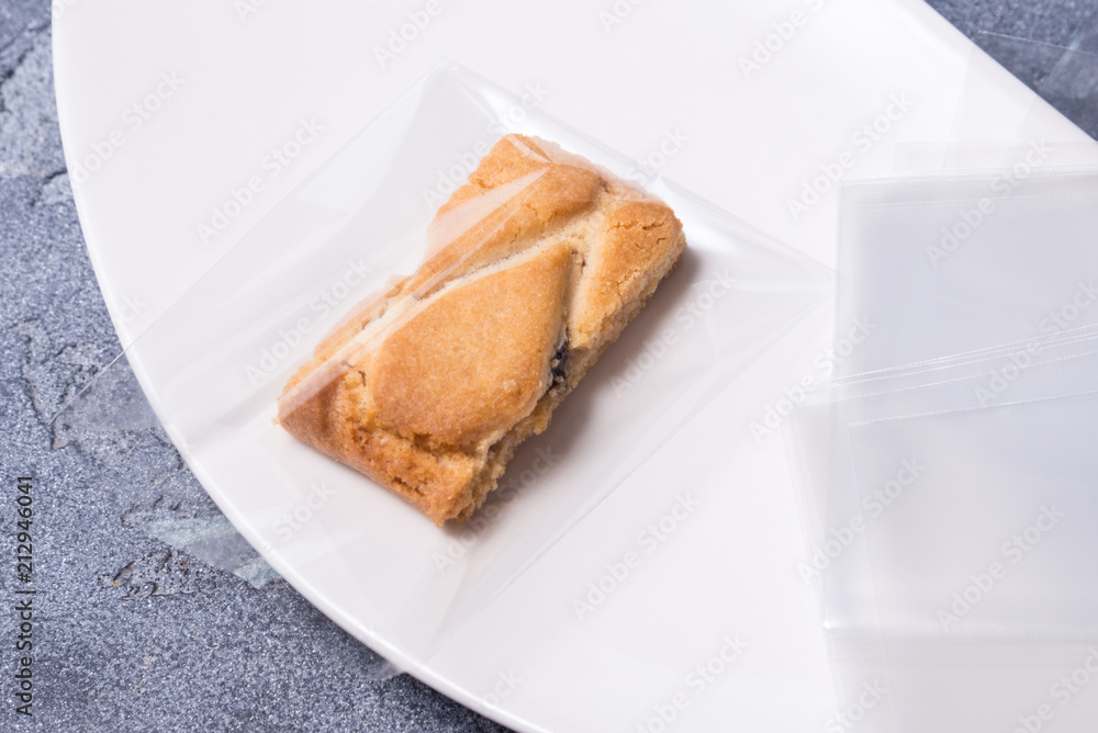 biscuit in cellophane bag on porcelain plate
