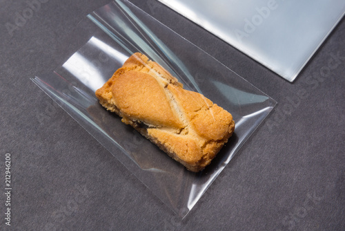 Billede på lærred biscuit in cellophane bag on black background