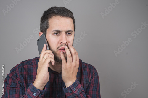 Portrait of surprised man talking on smartphone