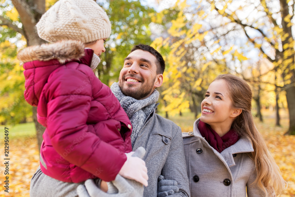 family, season and people concept - happy mother, father and little daughter walking at autumn park family, season and people concept - happy mother, father and little daughter walking at autumn park