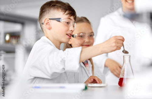 education  science  chemistry and children concept - kids or students with test tube making experiment at school laboratory