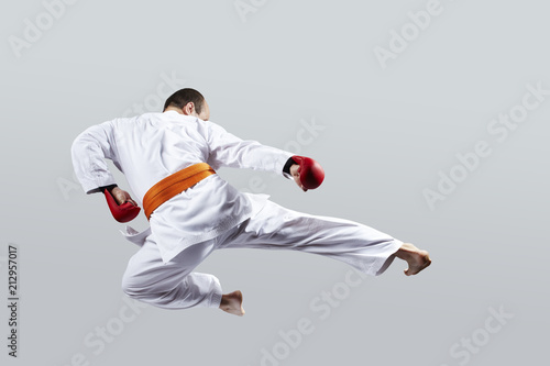 On a light background, the athlete beats a kick in the jump