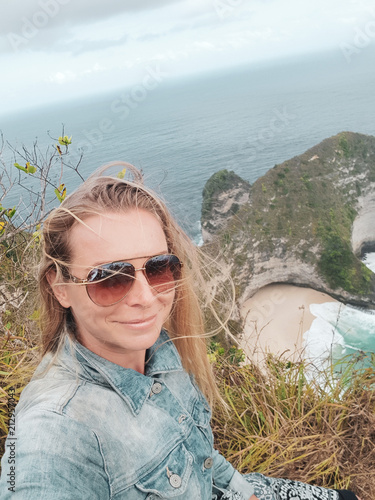 Pretty girl traveler at Kelingking Beach in Nusa Penida, Bali, Indonesia photo