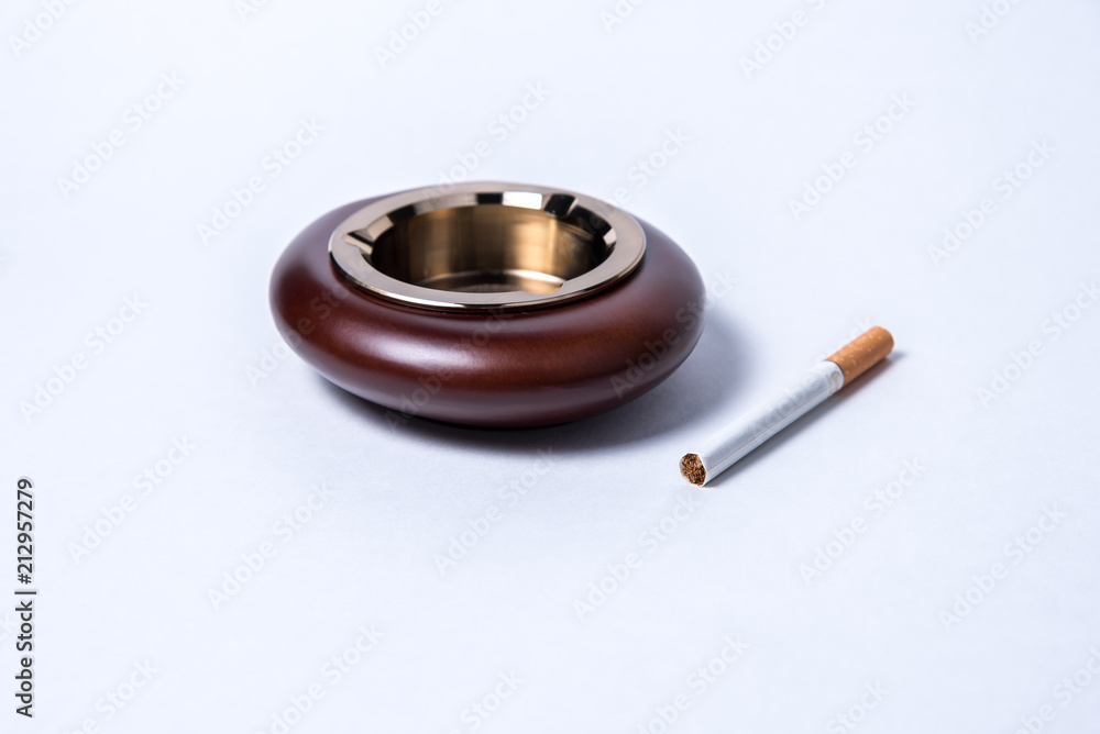 Stylish exquisite ashtray and cigarette on a white background