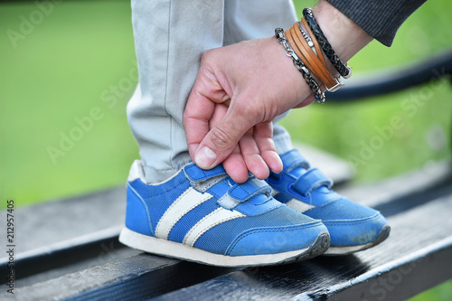Bild auf Leinwand man tying velcro snickers on child