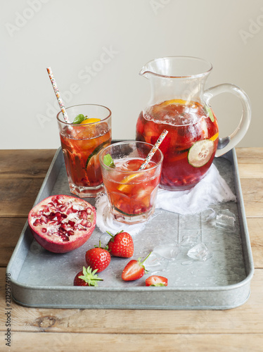 Pomegranate Pimms in jug with fruit on metal tray photo