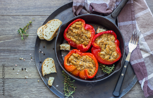Baked sweet bell peppers stuffed with tuna and bread served in a frying pan.