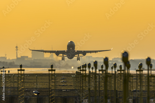 Front view of a plane taking-off in front of city skyline