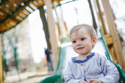 Portrait of cute baby girl on slide at playground