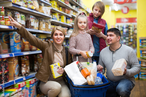 Happy family of four purchasing food