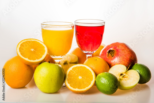 Ripe fruit and juice. Glasses of juice and fruits isolated on white.