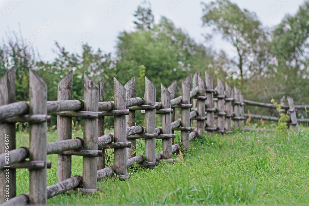 Small old wooden fence on open rustic field Small old wooden fence on open rustic field