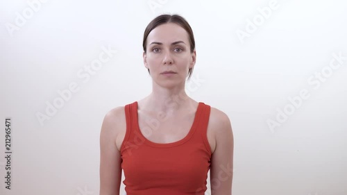 Portrait of a brunette woman turning the head left and right. Doing strengthening exercise for the neck. Isolated on white background.