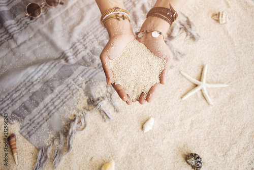 Young woman's hands full of sand