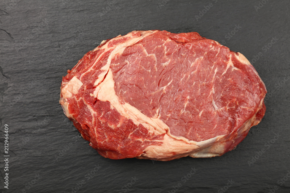 Close up raw beef ribeye steak on slate board Close up raw beef ribeye steak on slate board
