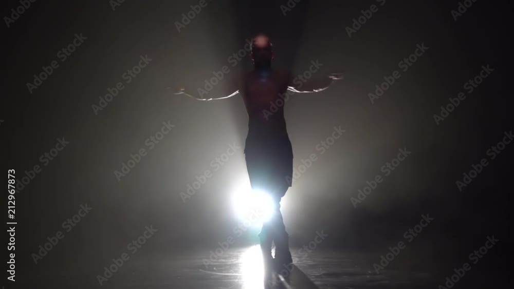 Man is dancing a strip . Black background. Silhouette. Slow motion Man is dancing a strip . Black background. Silhouette. Slow motion