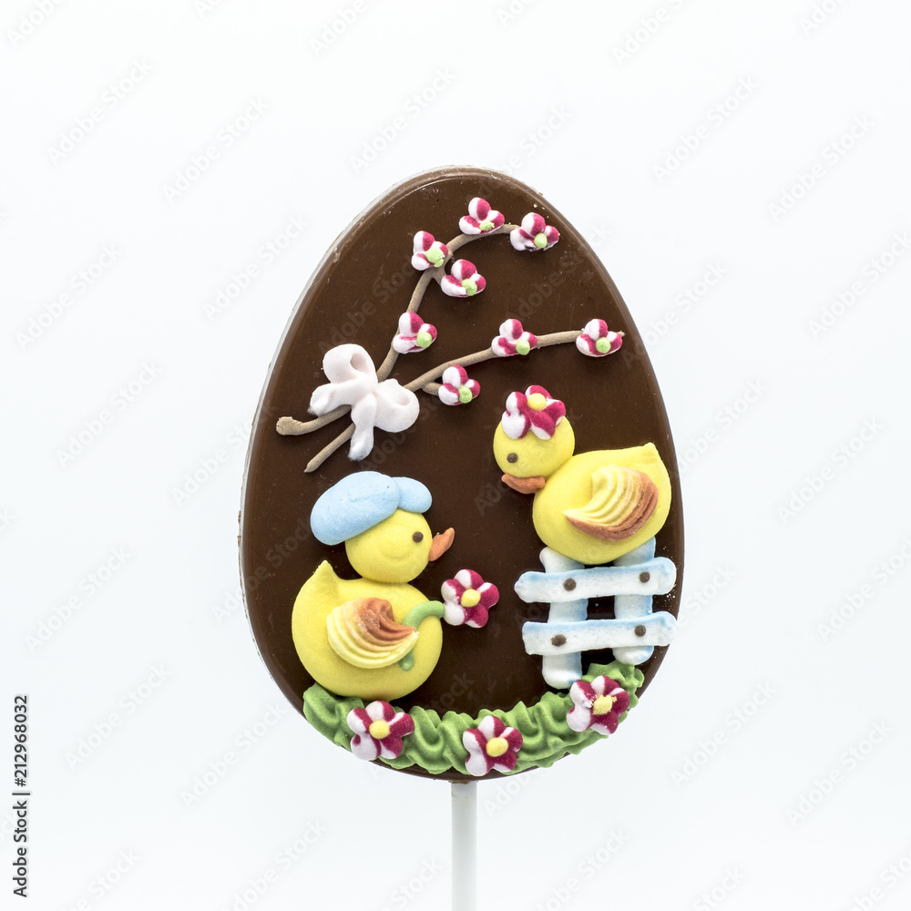 Lecca lecca di cioccolato a forma di uovo decorato con forme di zucchero in tema di Pasqua