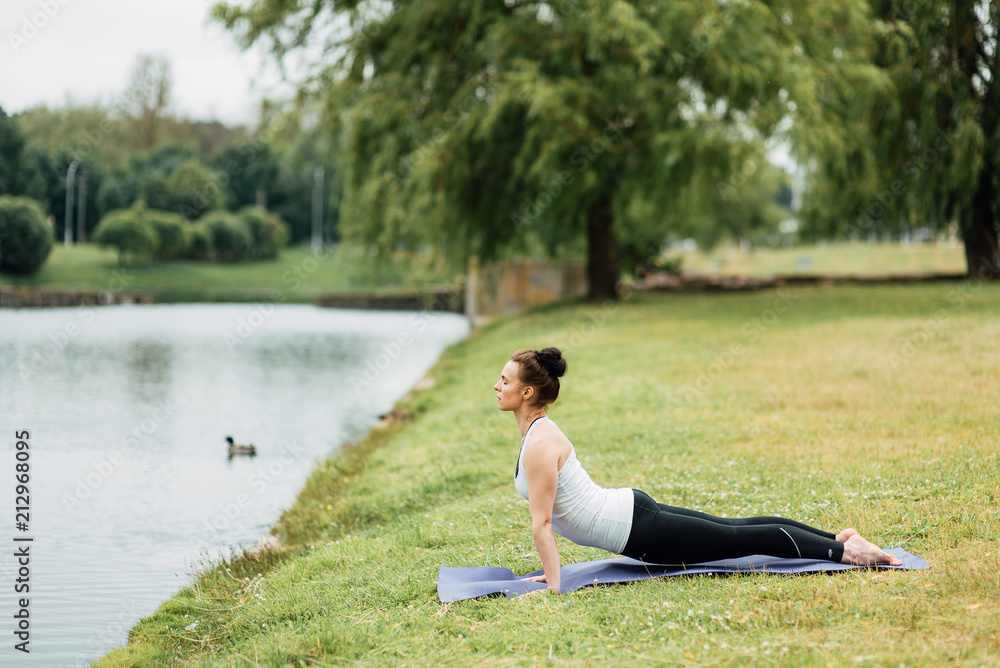 Young girl doing yoga in morning park.Woman Yoga - relax in nature