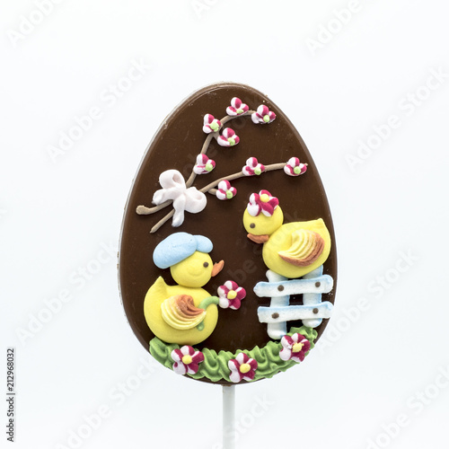 Lecca lecca di cioccolato a forma di uovo decorato con forme di zucchero in tema di Pasqua
