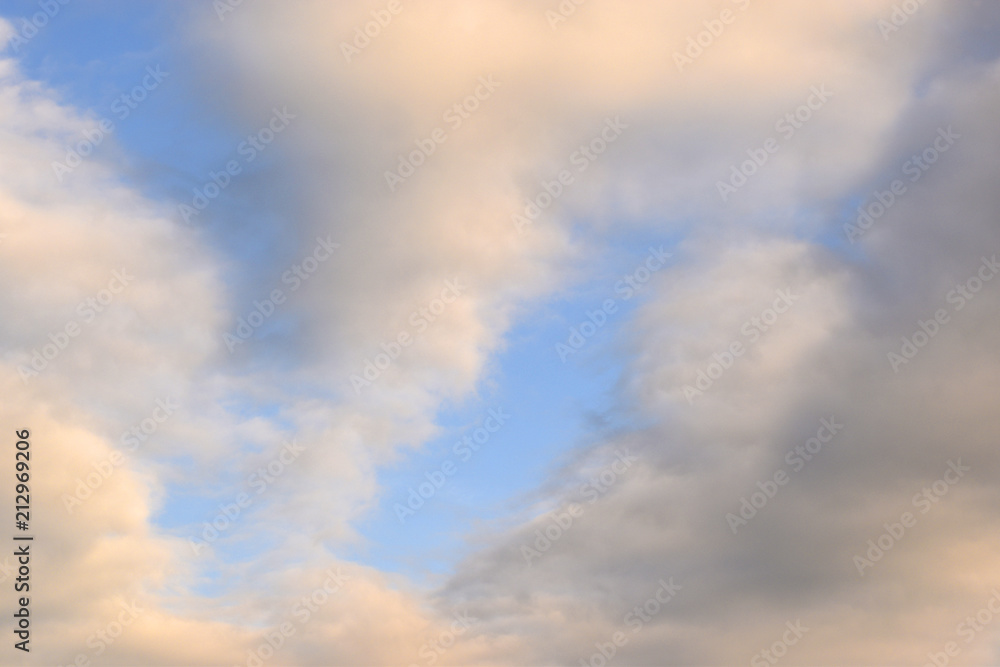 Fototapeta premium Figures from orange and gray clouds in the sky.
