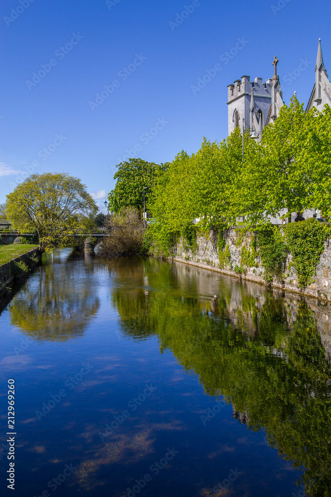 Corrib river with church, vegetation and reflection Corrib river with church, vegetation and reflection