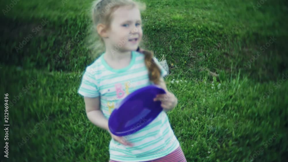 happy woman and daughter playing in frisbee in park happy woman and daughter playing in frisbee in park