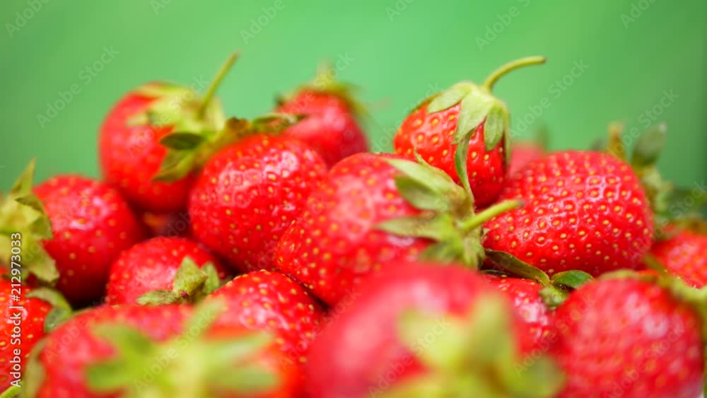 Fresh strawberries in a bowl at green background Fresh strawberries in a bowl at green background